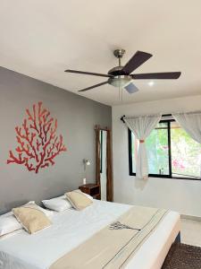 艾库玛尔Maya Eco Village的一间卧室配有一张带吊扇的床
