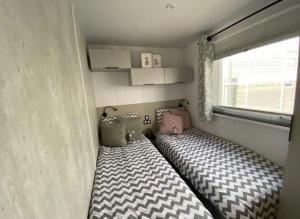 曲马勒姆Prachtig nieuw chalet met tuin op De Friese Wadden的小房间设有一张带窗户的床