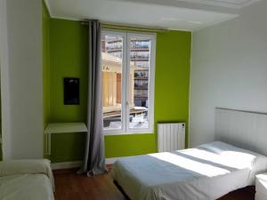 瓦伦西亚鲁萨法青年旅馆的绿色的客房设有床和窗户。