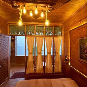 KejajarBagas Luxury Camp的一间卧室设有大窗户和窗帘