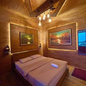 KejajarBagas Luxury Camp的木制客房内的一间卧室,配有一张床