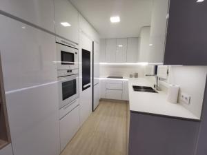 加的斯Casa Viento de Levante的白色的厨房配有白色的柜台和电器