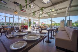 里瓦斯-巴西亚马德里德塞尔科蒂尔AB里瓦斯酒店的用餐室设有桌椅和窗户。