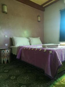 OuzoudDar Diafa Kaltom的一间卧室配有两张带紫色床单的大床