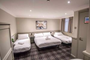 伦敦霍德华温切斯特酒店的酒店客房,配有两张带白色床单的床
