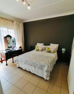 伯诺尼Garden and Park Leisure on Tugela的一间卧室配有一张大床和一架钢琴