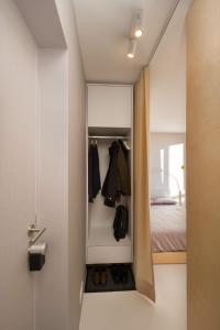 新戈里察Elegant Studio Apartment with Panoramic View的一间卧室配有一张床和一个衣柜,内配衣服