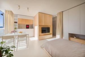新戈里察Elegant Studio Apartment with Panoramic View的一间卧室配有一张床,厨房配有桌子