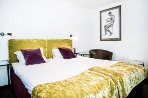 考纳斯HOF HOTEL的一间卧室配有一张带金色毯子的大床