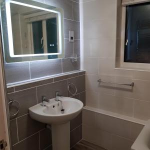 鲍内斯温德米尔Darcey's Apartment的一间带水槽和镜子的浴室