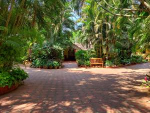 比纳里姆Palm Grove Cottages - Leisure Resort的公园里种有棕榈树和长凳的走道