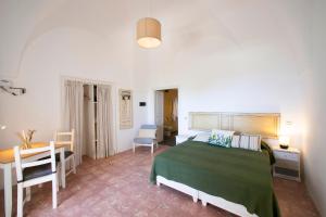潘泰莱里亚Il Mulino di Scauri的一间卧室配有一张床、一张桌子和一张书桌