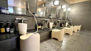 仙台仙台托普斯站西口胶囊旅馆的浴室设有一排盥洗盆和镜子