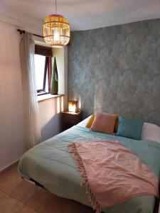 佩尼斯科拉迪奥斯埃斯特比恩酒店的一间卧室设有一张床、一个窗户和一个吊灯。