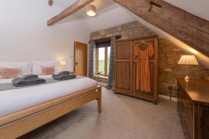 Hatch BeauchampSomerset Country Escape - Luxury barns with hot tubs的一间卧室设有一张大床和一个窗户。
