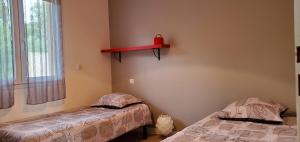菲加里Elsanais的卧室配有两张床,墙上设有红色架子。