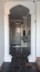 伯诺尼13th Avenue Guesthouse Benoni的带淋浴的浴室和瓷砖地板。