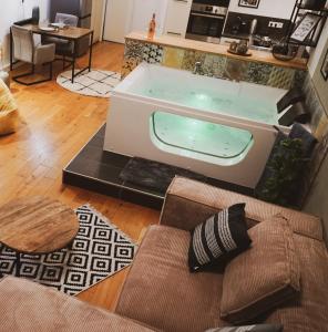 特里尔Stilvolles City-Loft mit privatem Whirlpool的客厅设有浴缸,配有沙发