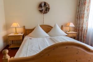 巴特迪克海姆Hotel Bad Dürkheim的一间卧室配有一张木床,桌子上配有两盏灯