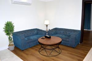 吉赞Sultanate Jazan的客厅里一张蓝色的沙发,配有桌子