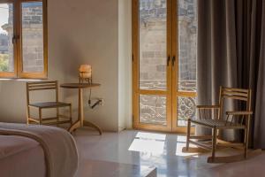墨西哥城Círculo Mexicano, a Member of Design Hotels的一间卧室配有两把椅子、一张桌子和一个窗户。