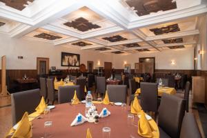 TarmiletHOTEL DES THERMES的用餐室配有桌椅和黄色餐巾