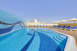 迪拜捷威酒店的一个带椅子和水滑梯的游泳池