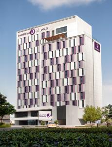 迪拜Premier Inn Dubai Barsha Heights的一座高大的白色建筑,上面有标志