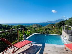 莱特鲁瓦西莱Villa Fresh&Cosy Trois-Ilets 3 étoiles的一个带甲板和椅子的游泳池以及大海