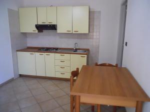 莫尔恰诺迪莱乌卡Agriturismo Specchiarussa的厨房配有白色橱柜和木桌