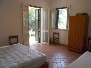 莫尔恰诺迪莱乌卡Agriturismo Specchiarussa的一间卧室设有一张床,并有通往庭院的门