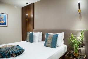 达喀尔勒迪安姆波尔住宅酒店的卧室配有带蓝色枕头的大型白色床