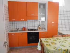 莫尔恰诺迪莱乌卡Agriturismo Specchiarussa的厨房配有橙色橱柜、水槽和床。