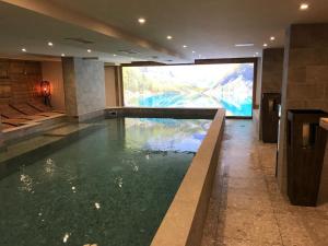 瓦勒迪泽尔Hotel La Toviere的大楼内一个带大屏幕的游泳池