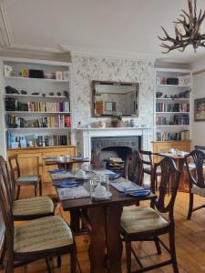 林顿St Vincent Guest House的一间带桌椅和壁炉的用餐室
