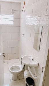 维拉可波斯Pousada alojacampinas的白色的浴室设有卫生间和水槽。