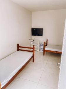 维拉可波斯Pousada alojacampinas的客房设有两张床和一台平面电视。