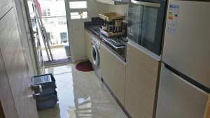 西迪拉哈尔Casabay Appart Vue Sur Piscine的厨房配有炉灶、洗衣机和烘干机
