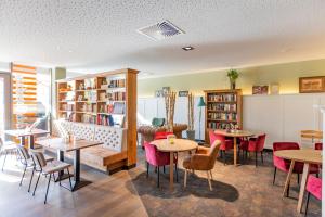 达豪莫迪酒店的一间带桌椅和书架的餐厅