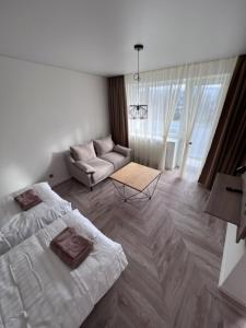 Naujoji AkmenėMOYA Apartmentai的客厅配有床和沙发