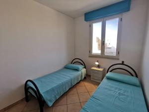 托雷圣乔万尼乌Appartamento Ghirigoro 1的带窗户的客房内的两张床