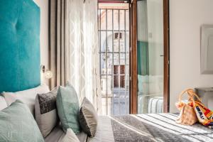 埃希哈Amphora Alojamiento Ecija的卧室配有带枕头的床铺和窗户。