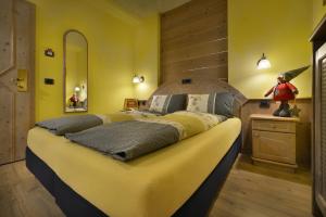 利维尼奥皮克罗蒙德酒店的一间卧室设有一张黄色墙壁的大床