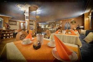 利维尼奥皮克罗蒙德酒店的用餐室设有2张带橙色餐巾的桌子