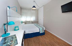 桑坦德阿兰萨苏一室公寓酒店的小房间设有床铺和电视