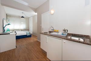 桑坦德阿兰萨苏一室公寓酒店的一个带水槽的厨房和一张位于客房内的床