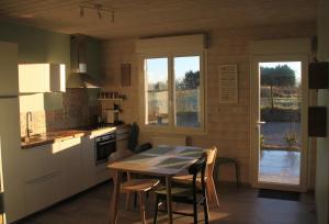 Saint-AulaireGîte de la Tuillère, maison contemporaine en bois avec vue et piscine的厨房配有桌椅