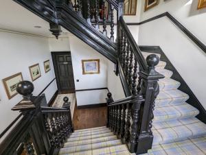 因弗内斯Cambeth Lodge的一座有黑色栏杆的房子里的楼梯