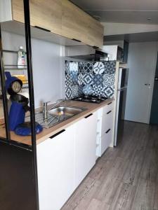 圣拉斐尔Charmant Mobil home avec Vue mer exceptionnelle的小厨房配有白色橱柜和水槽