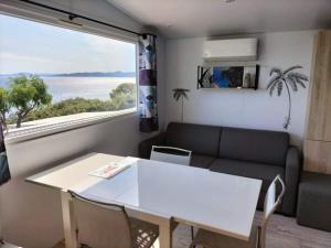圣拉斐尔Charmant Mobil home avec Vue mer exceptionnelle的客厅配有桌子、沙发和窗户
